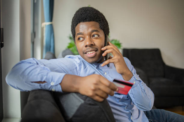 istock Cheerful man doing online shopping 1447940369