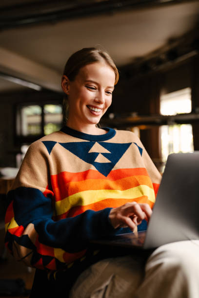 istock Young smiling woman working on laptop in cafe 1447940953