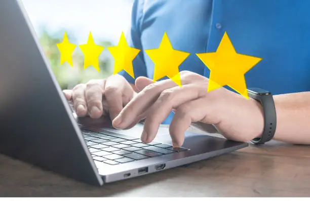 Photo of customer man hand typing on keyboard laptop to giving 5 star to review service. Five star rating feedback icon level for satisfaction of business concept