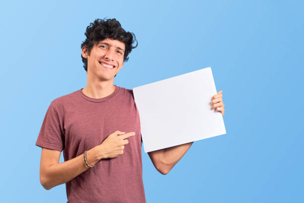 istock Happy young man showing a placard or advertisement on flat lay. 1447948672
