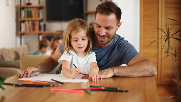 istock Father and daughter having good time drawing at home together 1447950235