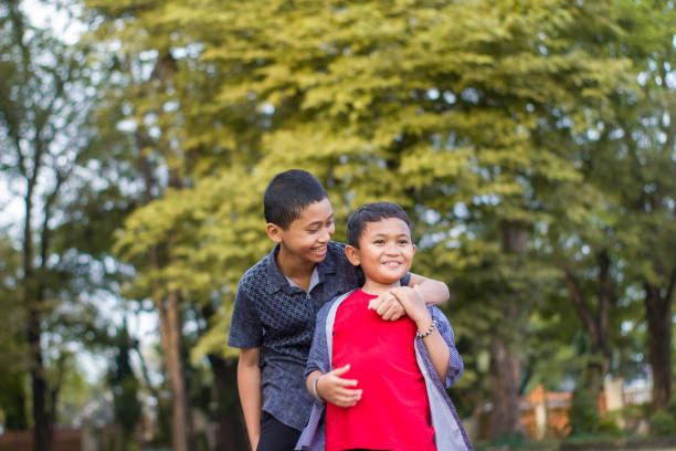 istock two boys joking and playing in the park 1447953487