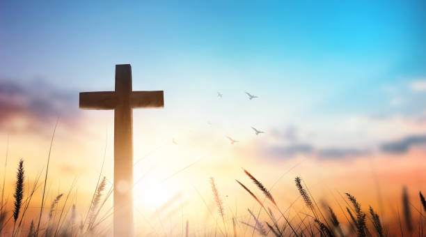 Christian wooden cross on sunset background. stock photo