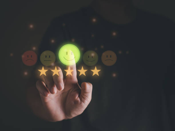 istock Client's hand touching smiley face to feedback customer evaluation or survey, good rating with five stars. 1447957432