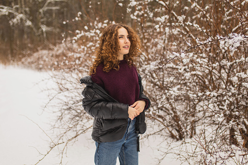Woman enjoying vacation. Girl laughing in nature. Feel happiness. Frost and snow on trees. Charming smile