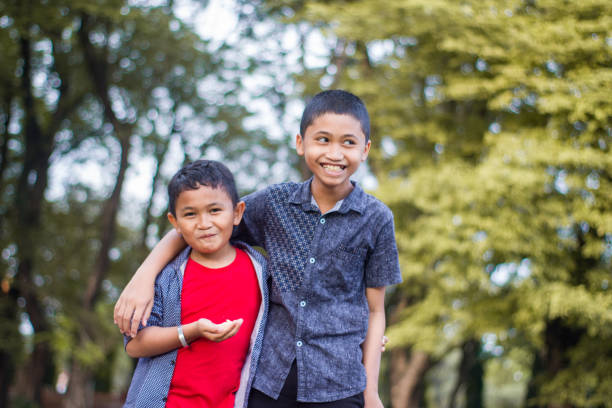 istock two boys joking and playing in the park 1447959269