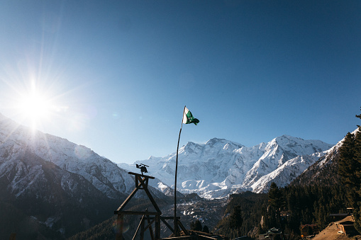 The Pakistan flag on the background of the Nanga Parbat mount in a sunny day