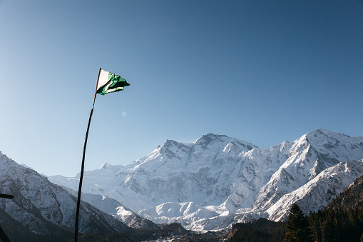 The Pakistan flag on the background of the Nanga Parbat mount in a sunny day