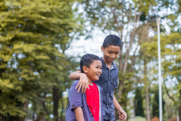 istock two boys joking and playing in the park 1447961863