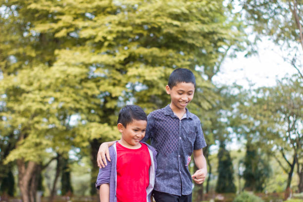 istock two boys joking and playing in the park 1447961964