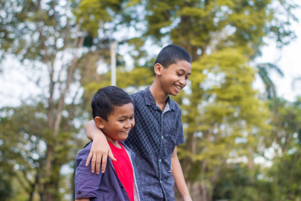 istock two boys joking and playing in the park 1447962189