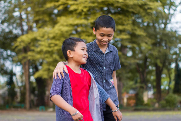 istock two boys joking and playing in the park 1447962191