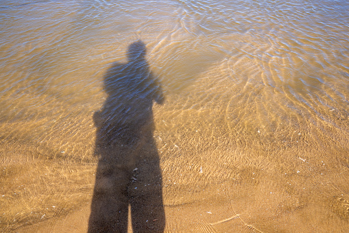 A shadow on the sea and sand