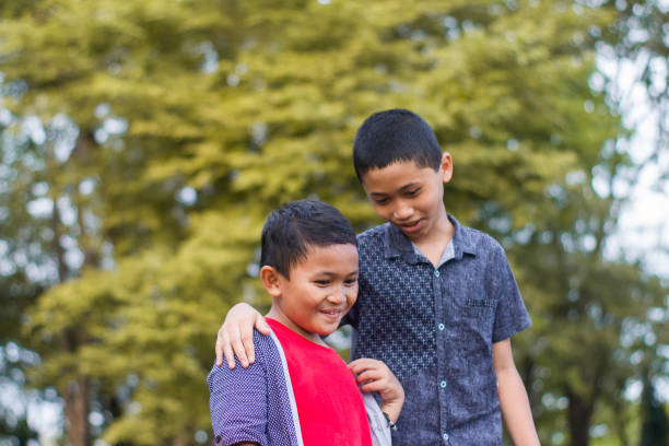 istock two boys joking and playing in the park 1447963150