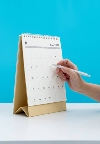 Woman hand with pen writing on calendar page