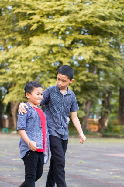 istock two boys joking and playing in the park 1447963996