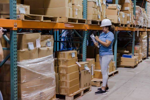 istock Mid adult manager documents inventory on shelves in warehouse 1447965773