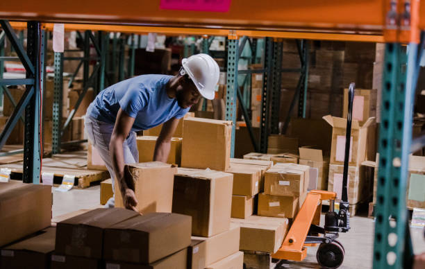 istock Young male trainee loads boxes on pallet jack in warehouse 1447965827