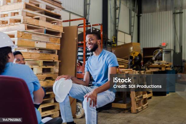 Young Male Warehouse Trainee Takes Goodnatured Ribbing From Coworkers Stock Photo - Download Image Now