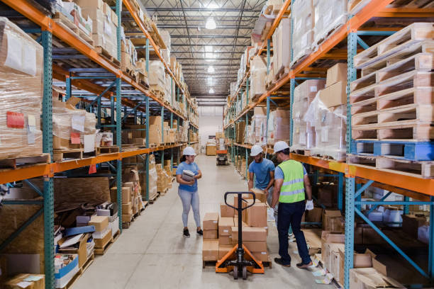 istock Diverse employees work together to load pallet jack with merchandise 1447965894