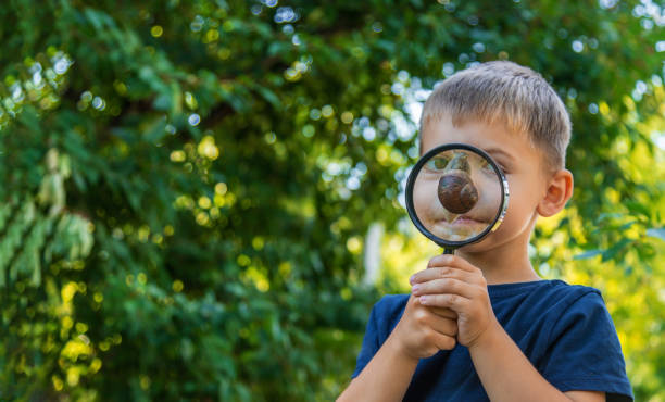 istock The child looks at the snail nature. Selective focus. 1447966049