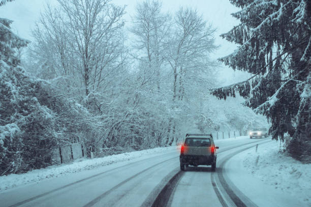 istock Driving in winter: road in the forest with snow 1447966849