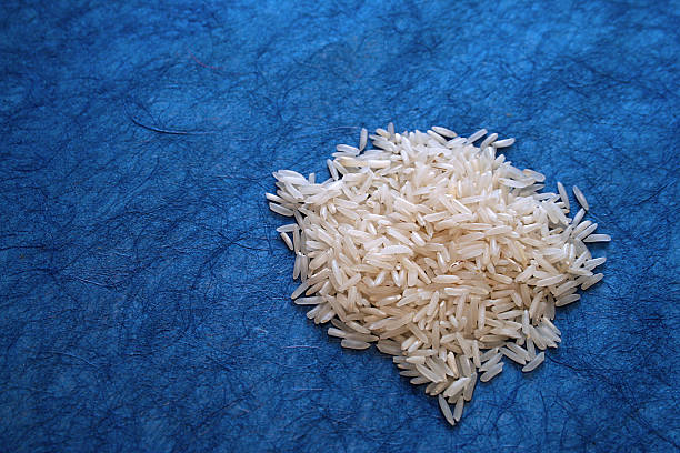 Small mound of white rice on blue background stock photo