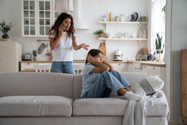 madre arrabbiata della donna severa che tiene lo smartphone che parla con il marito che si lamenta della figlia adolescente - teacher women cruel displeased foto e immagini stock