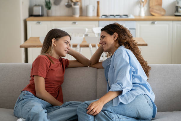 mère aimante écoutant sa fille avec empathie et compréhension, enfant partageant des secrets avec maman - mid teens photos et images de collection