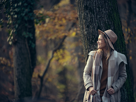 Young happy woman day dreaming while spending an autumn day in nature. Copy space. Photographed in medium format.