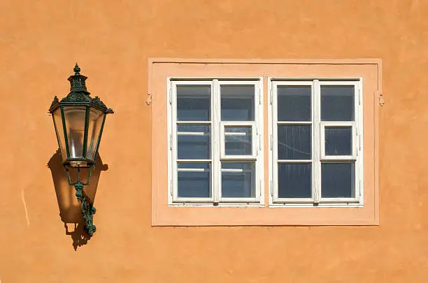 Gas-lamp and wooden framed window at the wall of an old mansion in Prague, Czech Republic