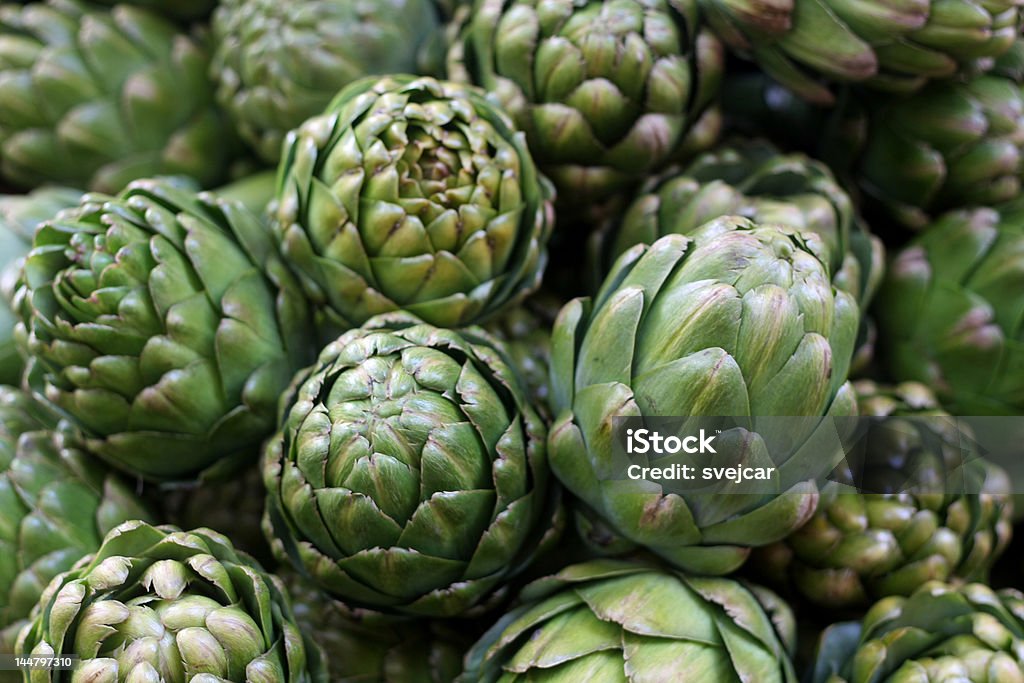 Stand of Artichokes A stand of fresh artichokes at a farmer's market with a soft background. Artichoke Stock Photo