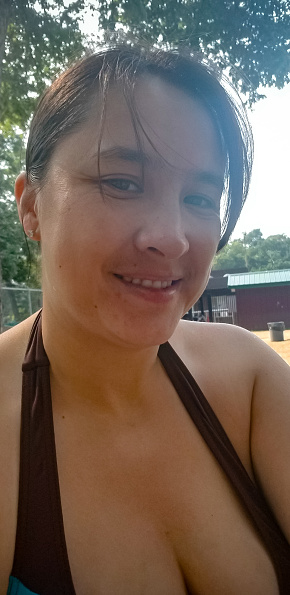 A canadian woman without makeup on has taken a selfie at the pool in the summertime