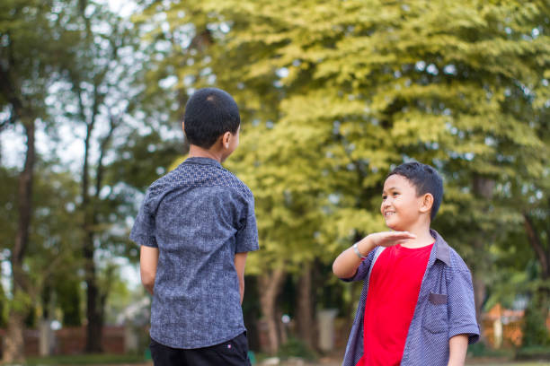 istock two boys joking and playing in the park 1447977558