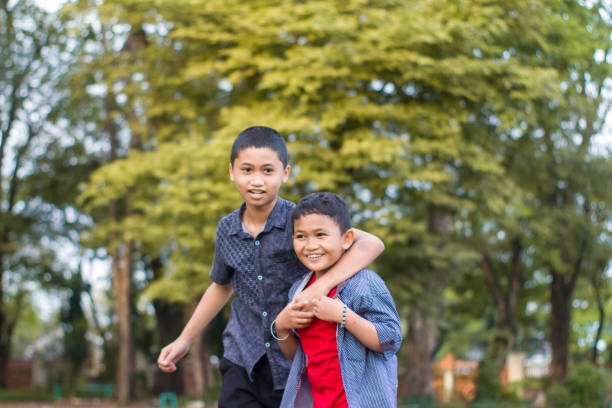 istock two boys joking and playing in the park 1447977626