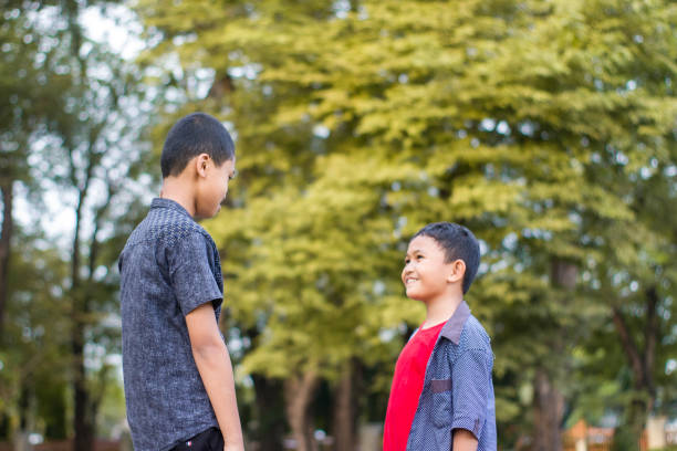 istock two boys joking and playing in the park 1447977724