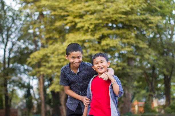 istock two boys joking and playing in the park 1447977977