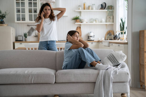 madre arrabbiata della donna severa che tiene lo smartphone che parla con il marito che si lamenta della figlia adolescente - teacher women cruel displeased foto e immagini stock