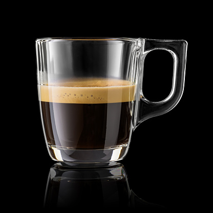 Half cup of espresso coffee isolated on black background.