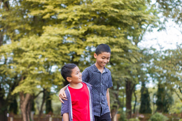 istock two boys joking and playing in the park 1447981597