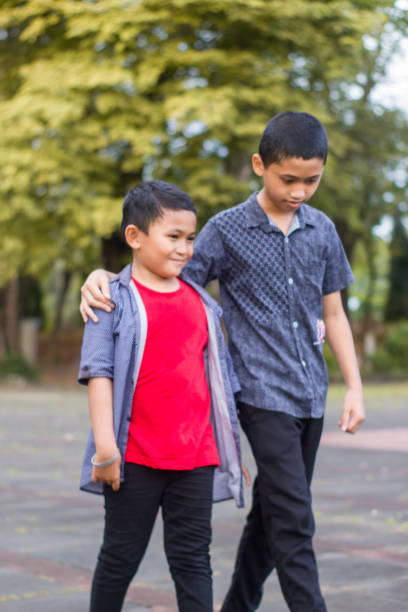 istock two boys joking and playing in the park 1447981616