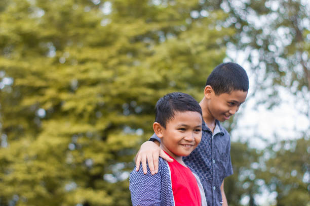 istock two boys joking and playing in the park 1447982277
