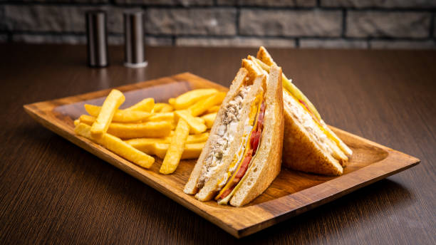 club sandwich e patatine fritte isolati sulla tavola di legno vista laterale sul tavolo fast food - club sandwich sandwich french fries turkey foto e immagini stock