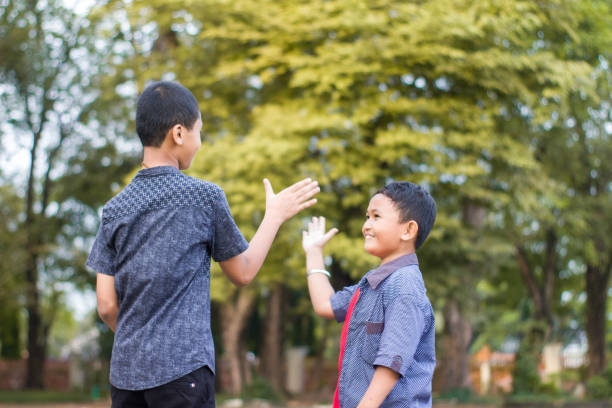 istock two boys joking and playing in the park 1447982779