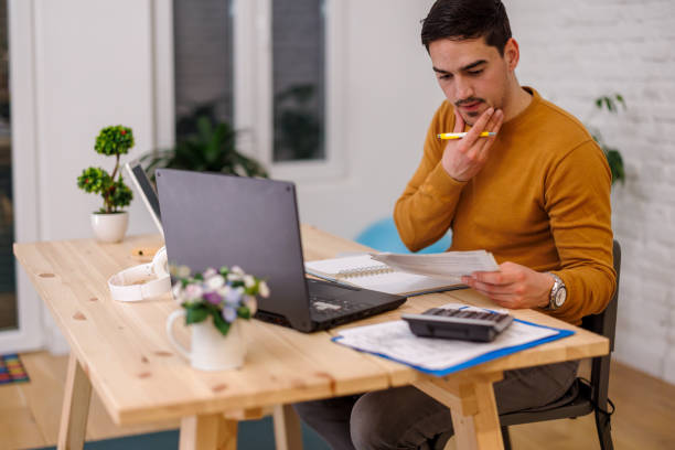 istock A handsome businessman is checking papers while working from home. 1447984284