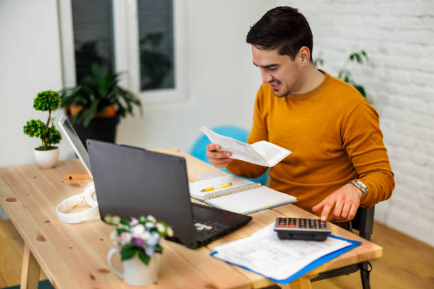 istock A young man is working at home analyzing results with a calculator. 1447985155