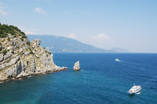 two cruise ships and rock cliff in blue sea. Black Sea, Crimea, Ukraine.