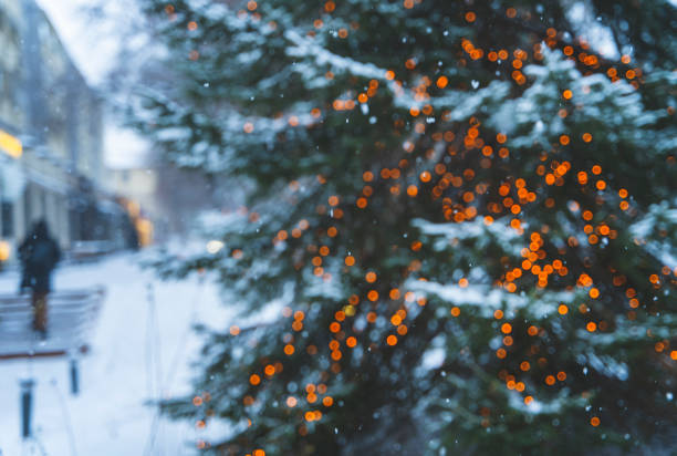 istock Christmas tree with lights glowing in the snow 1447987486