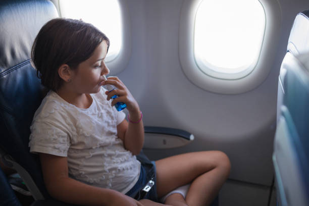 istock Child flying via airplane and using nasal spray 1447987491