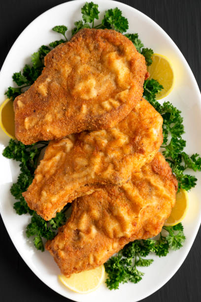 istock Homemade Fried Pork Chops on a White Plate, top view. Flat lay, overhead, from above. 1447987745